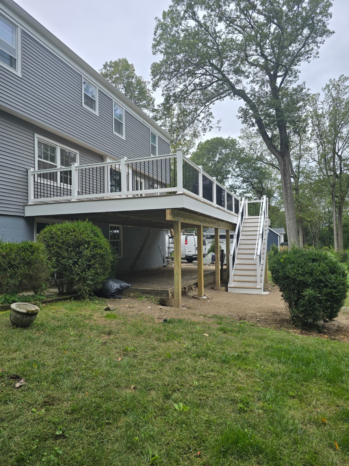 Composite deck with dark railings and wide backyard stair landing